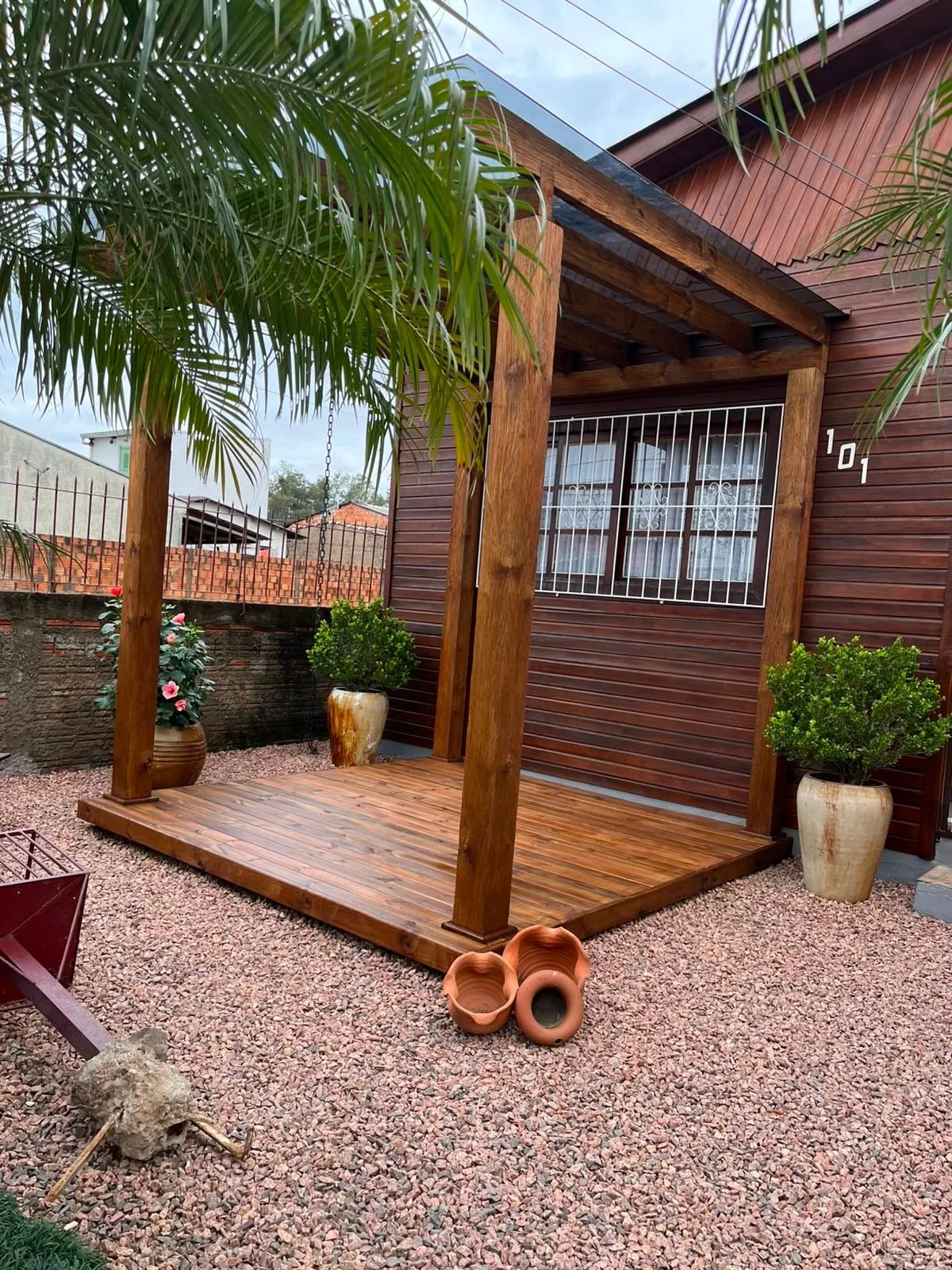 Pergolado de madeira tratada integrado a deck e jardim